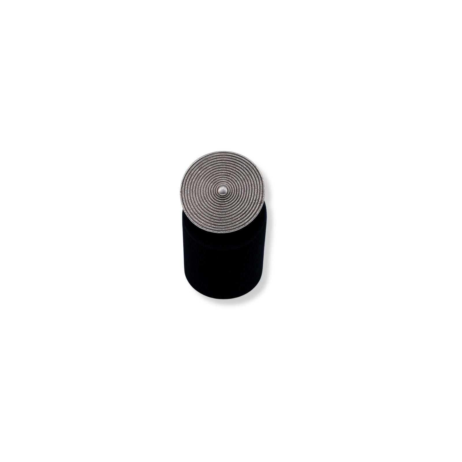 Silver-plated statement ring with concentric circular design, displayed on black stand