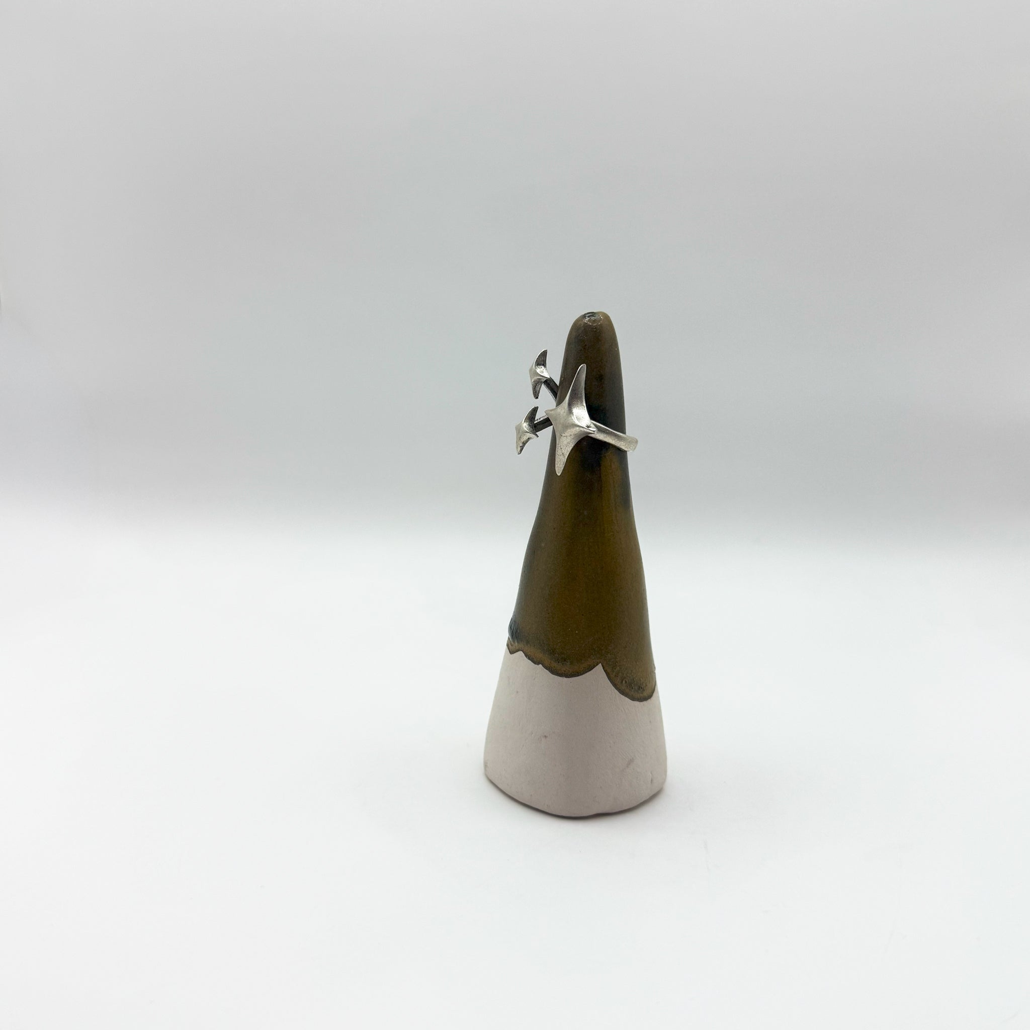 Ceramic cone with a silver star-shaped object on a white background