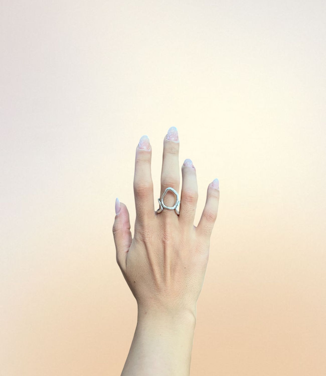 Silver-plated open swirl ring with twin curved arms and organic circular center, worn on hand