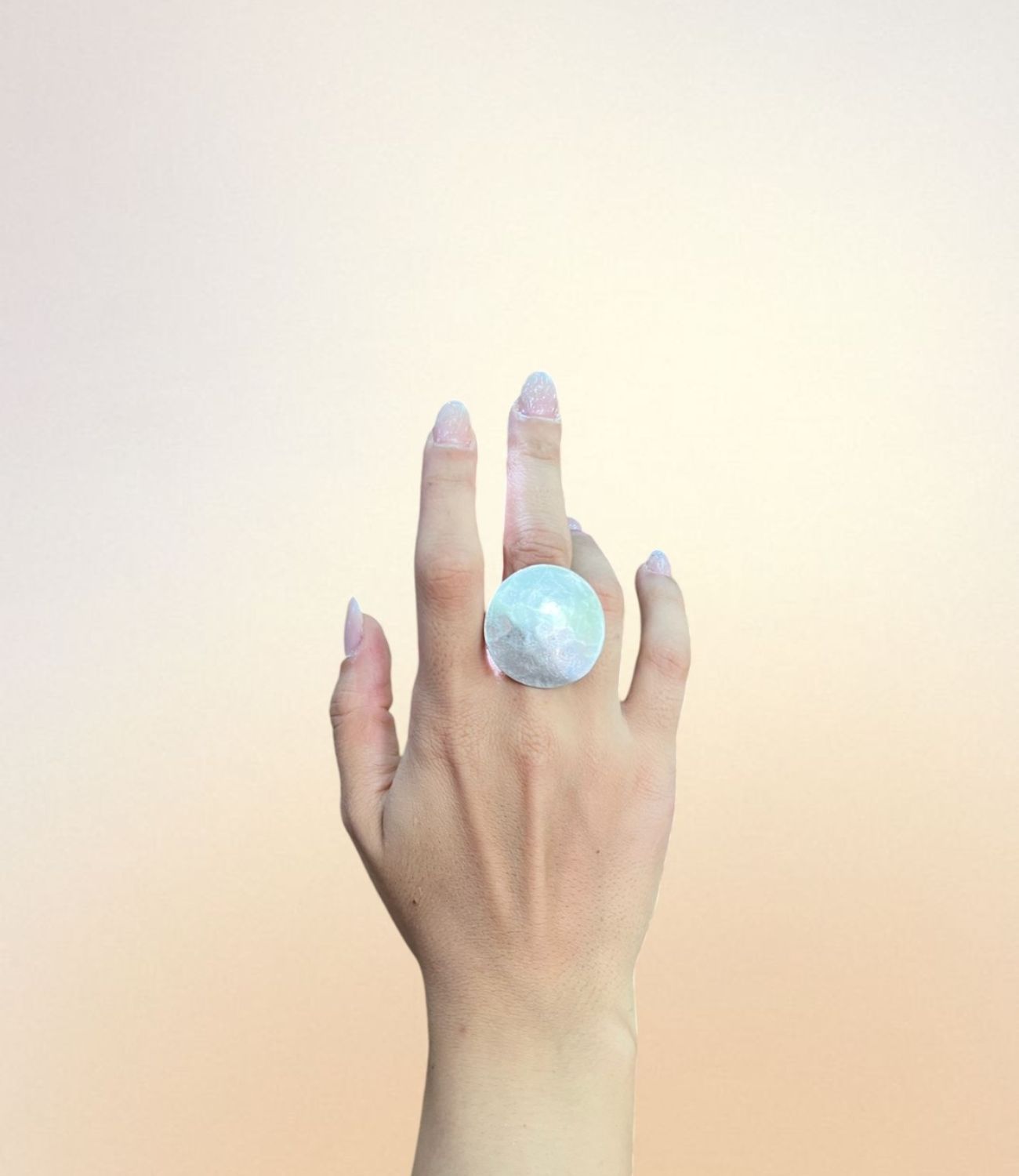 Large silver-plated round disc ring with hammered texture, worn on hand